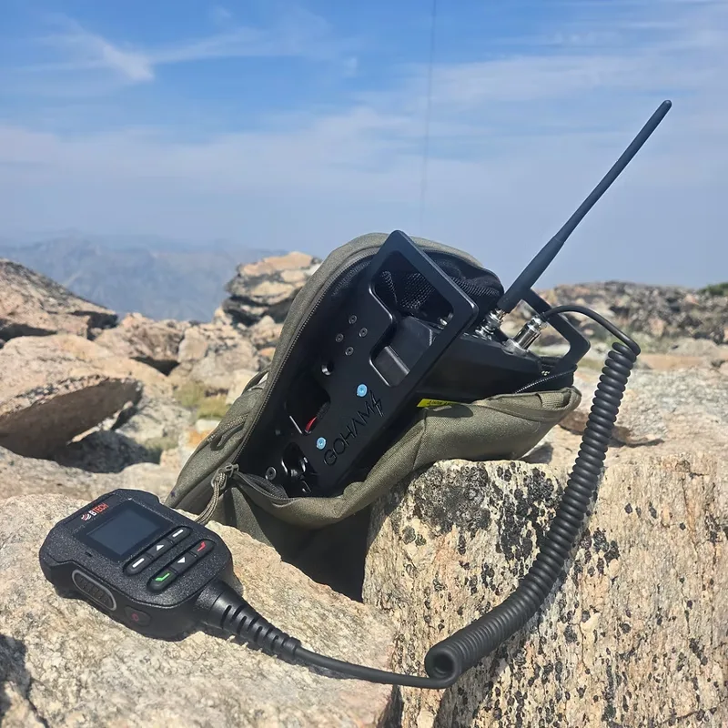 GoHam B2M portable go-bag carrier for BTech UV-50 Pro mobile radio, deployed on rocks with mountain backdrop
